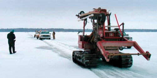 Utility installation equipment operating on frozen lake during winter field work