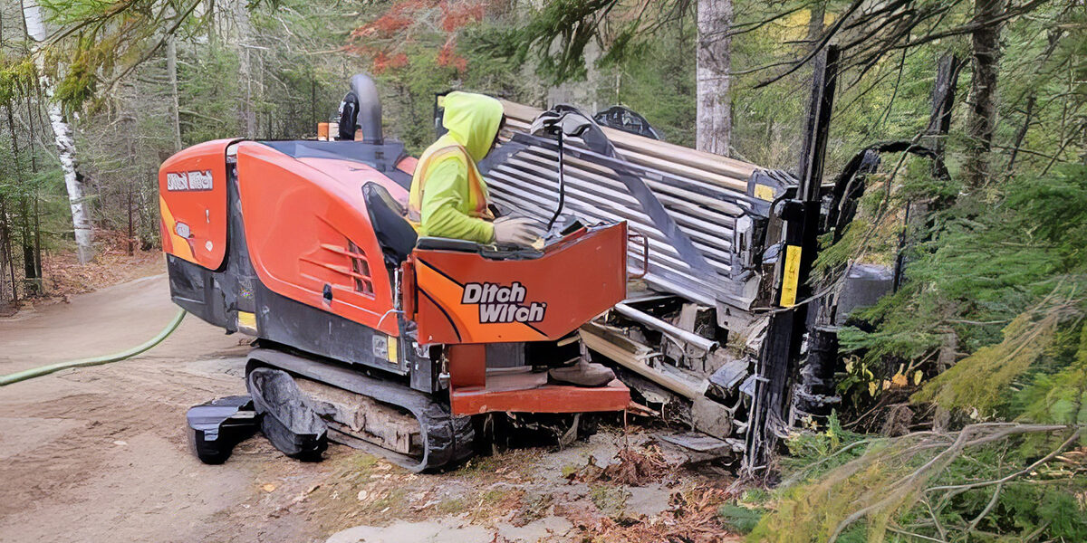 A North Central Services worker getting cabling ready in a forest.
